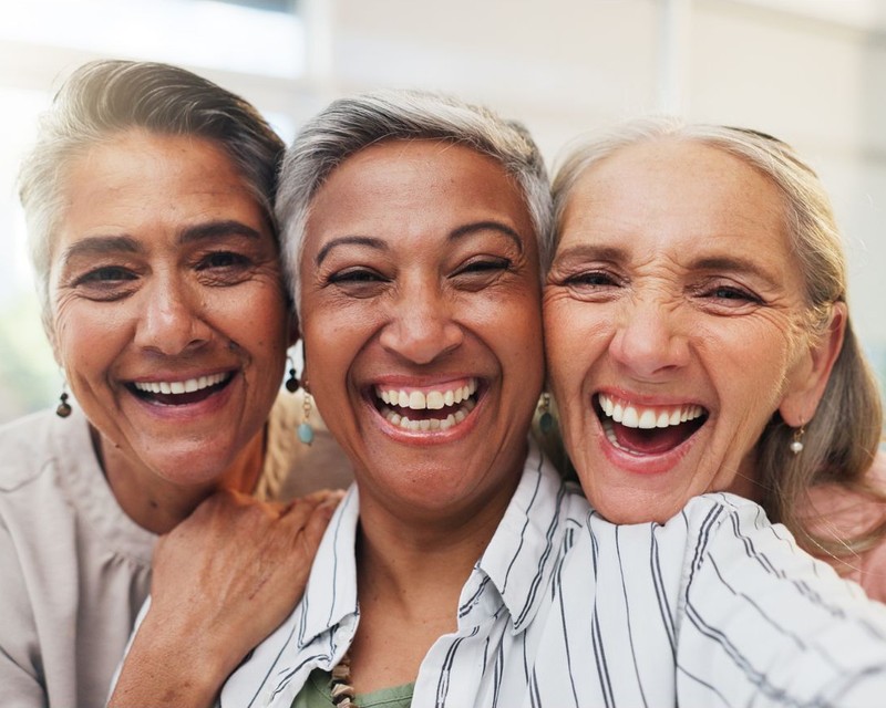 Three diverse women laughing together